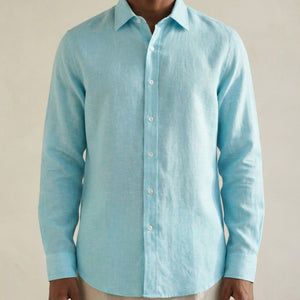 Close-up detail of turquoise linen shirt showing natural linen texture