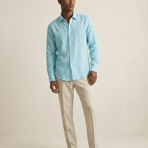 Men wearing turquoise linen shirt styled with light summer trousers