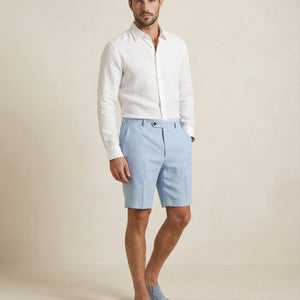 Men’s light blue linen shorts worn with white linen shirt, full outfit view