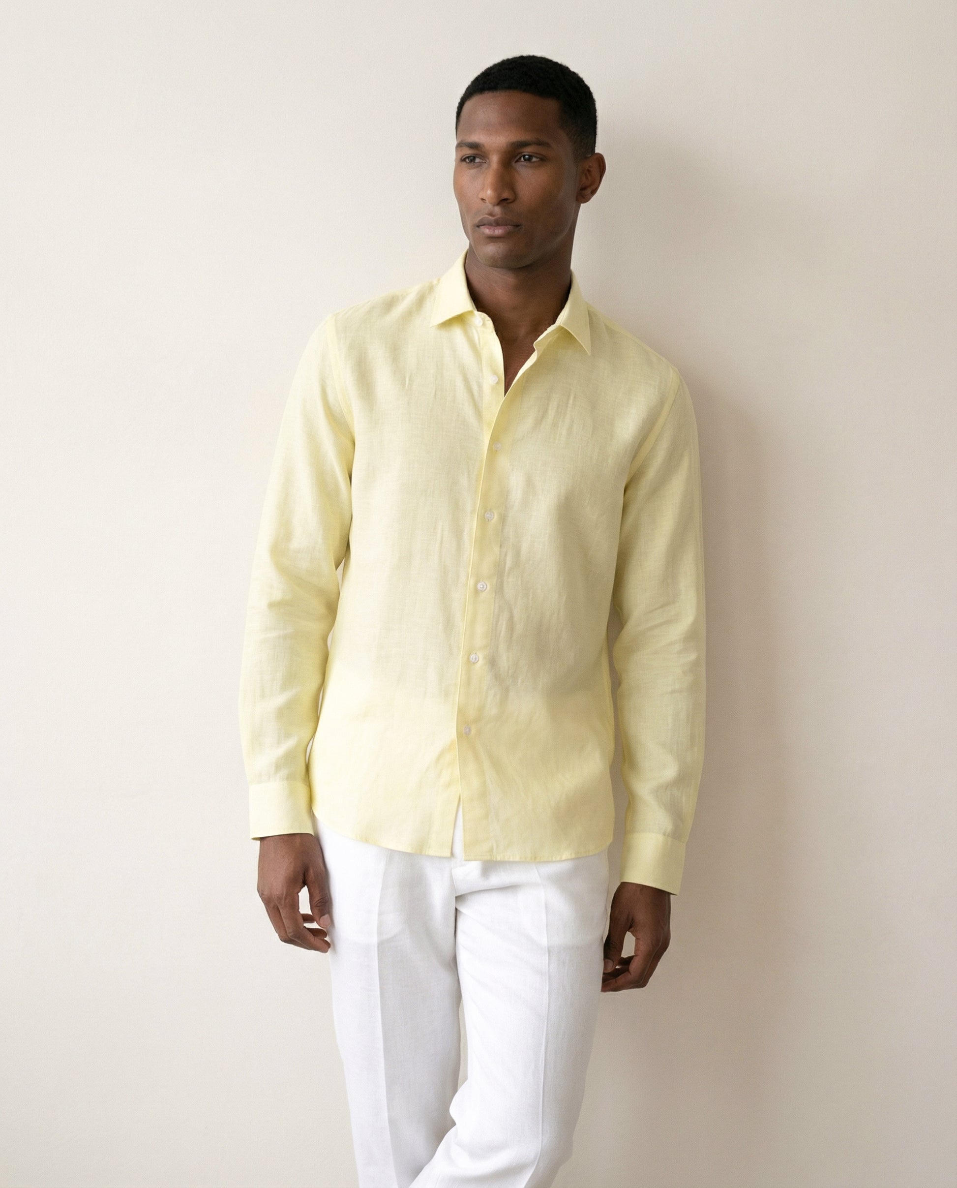 Light yellow linen shirt worn by model showing relaxed tailored fit