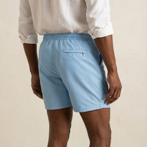 Back view of Lumari light blue swim shorts featuring welt back pocket.