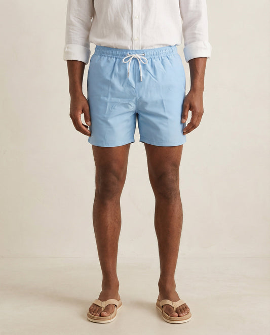 Lumari light blue swim shorts front product view on model.