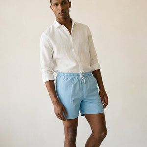 Lumari light blue swim shorts mid-body view showing elastic waistband and tailored silhouette.