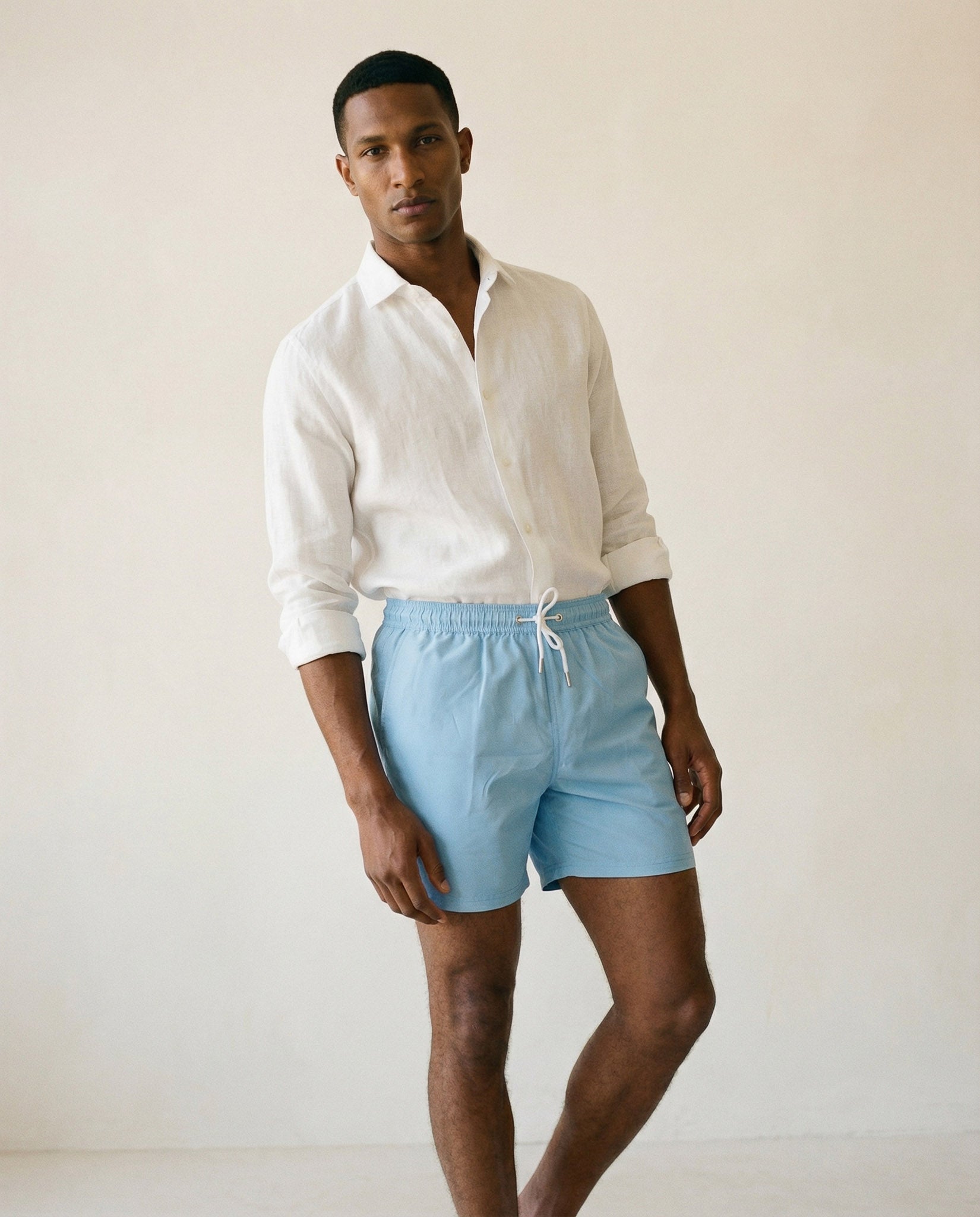 Lumari light blue swim shorts mid-body view showing elastic waistband and tailored silhouette.