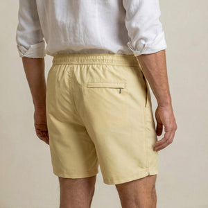 Back view of Lumari swim shorts in light yellow featuring rear zip pocket.