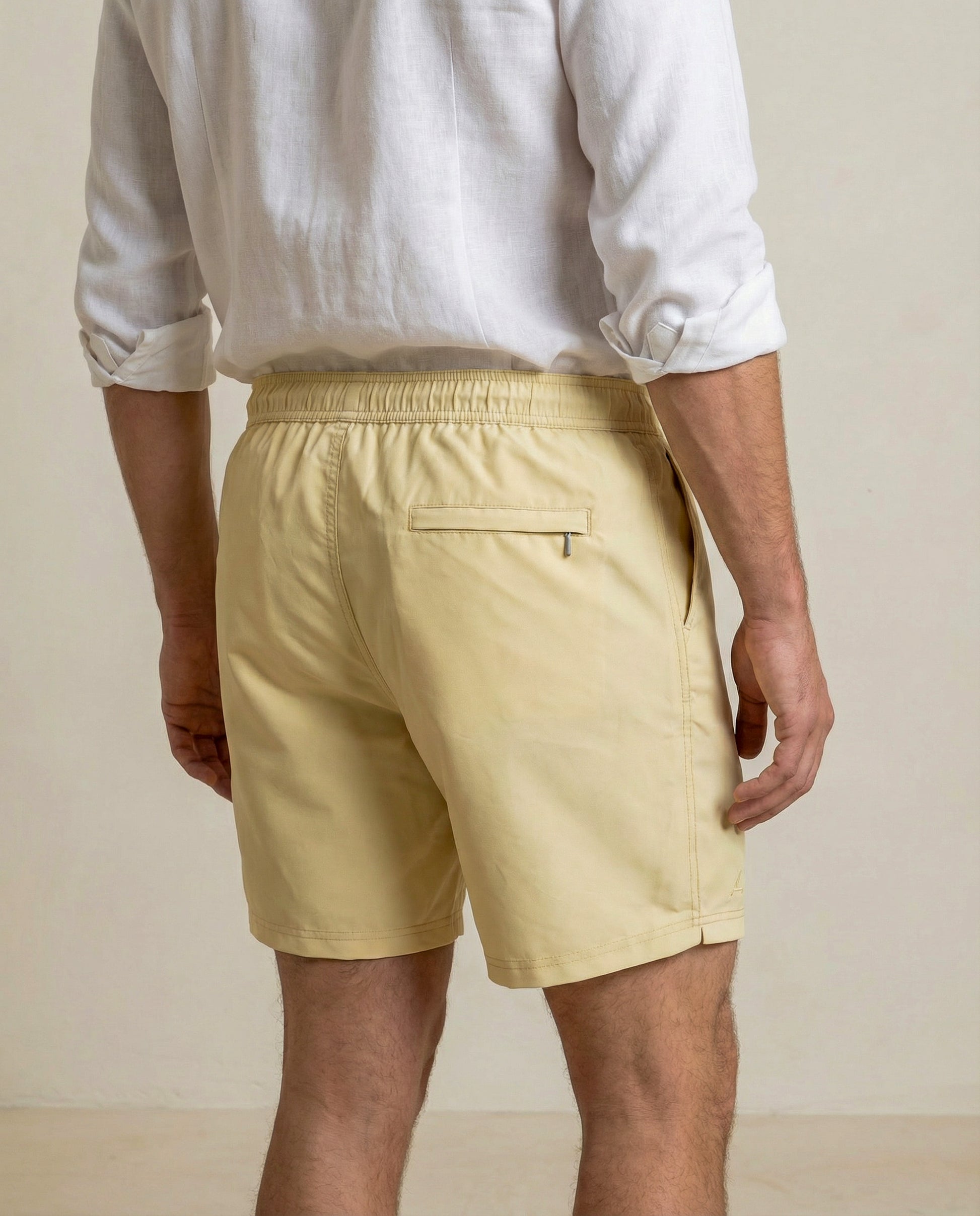 Back view of Lumari swim shorts in light yellow featuring rear zip pocket.