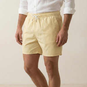 Detail view of Lumari light yellow swim shorts showing side pocket and drawstring waistband.