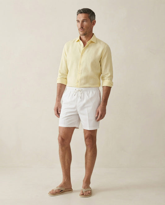 Apprivió Lumari white swim shorts styled with linen shirt, full body view
