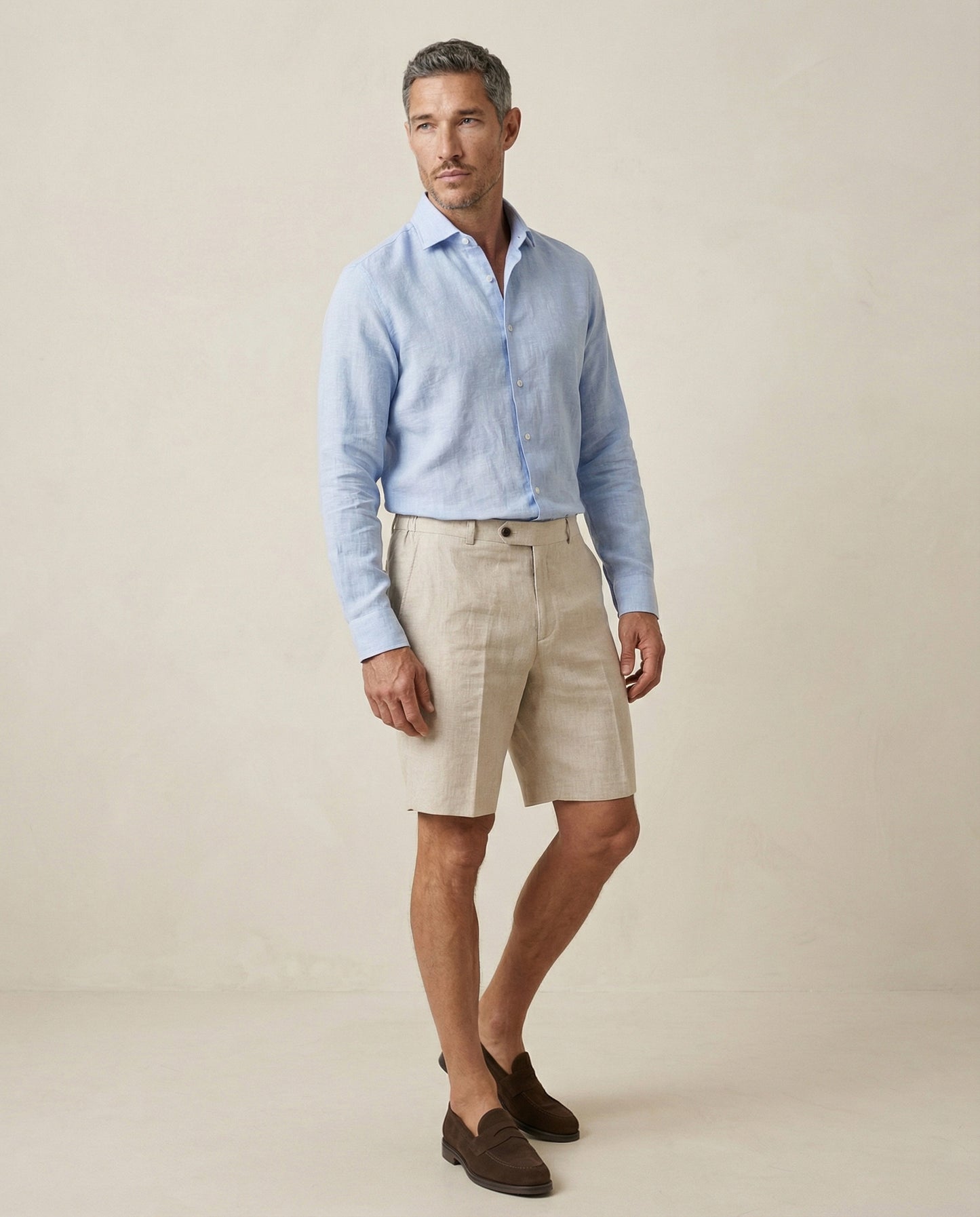 Men’s natural linen shorts worn with light blue linen shirt, full outfit view