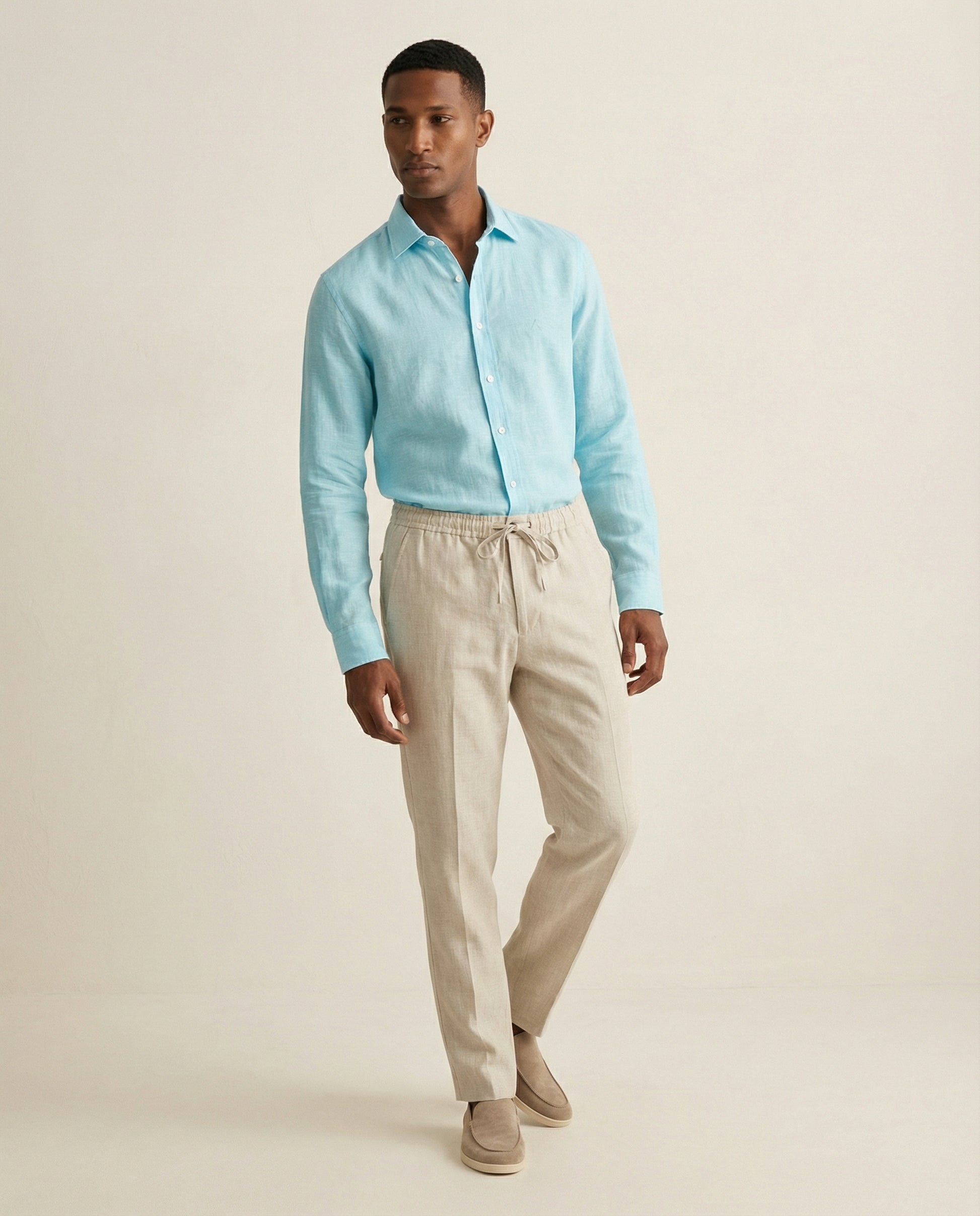 Men’s Noya natural linen trousers worn with light blue linen shirt, full outfit view