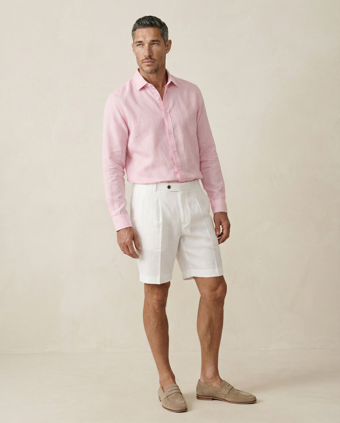 Men’s pearl white linen shorts worn with pink linen shirt, full outfit view