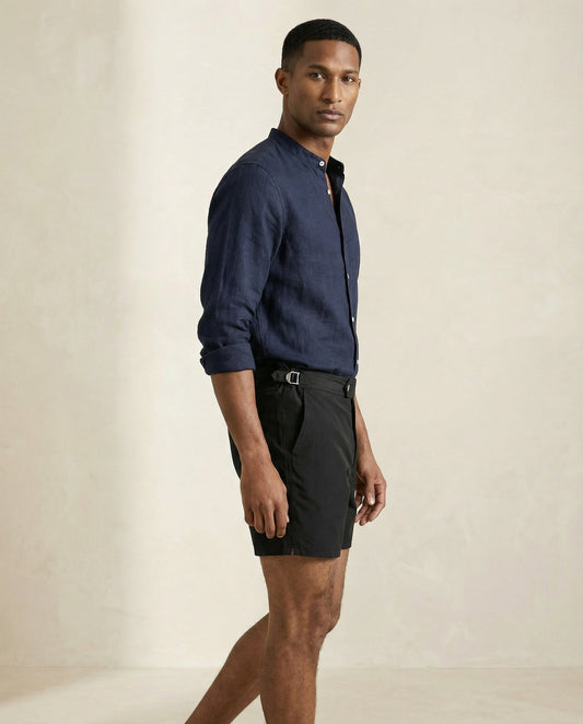 Mid-length view of Riviera black swim shorts showing structured waistband and tailored fit.