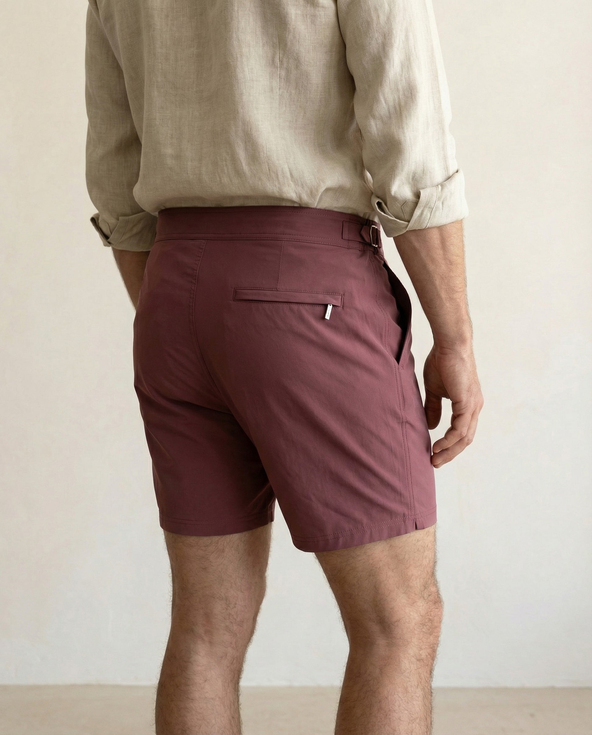 Back view of Riviera burgundy tailored swim shorts with minimalist rear pocket and refined finish.