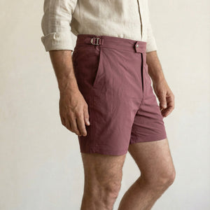 Close-up of Riviera burgundy swim shorts showing adjustable side buckle and clean waistband construction.