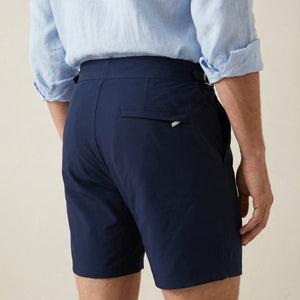 Back view of Riviera navy swim shorts with clean tailored silhouette and rear pocket.