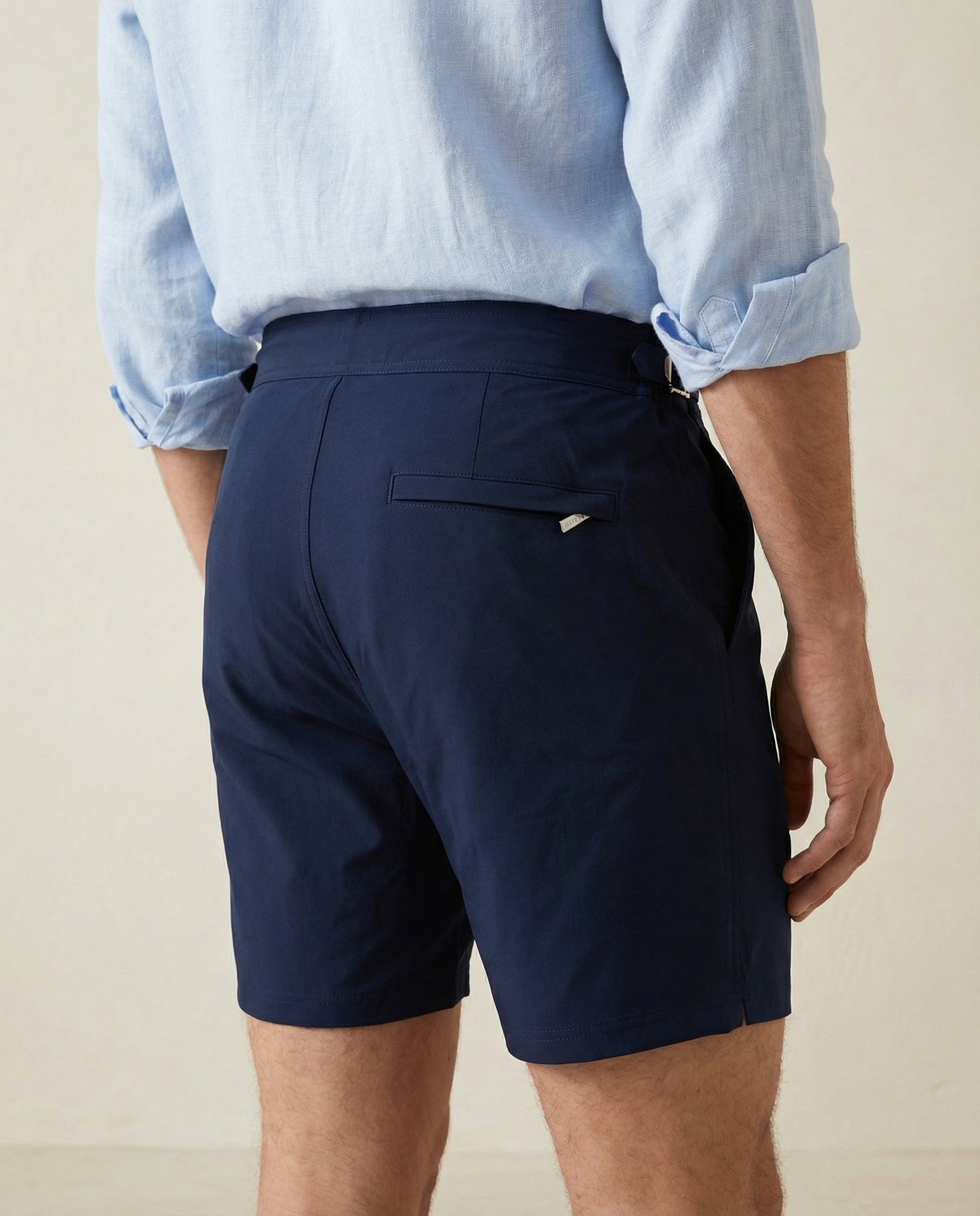 Back view of Riviera navy swim shorts with clean tailored silhouette and rear pocket.