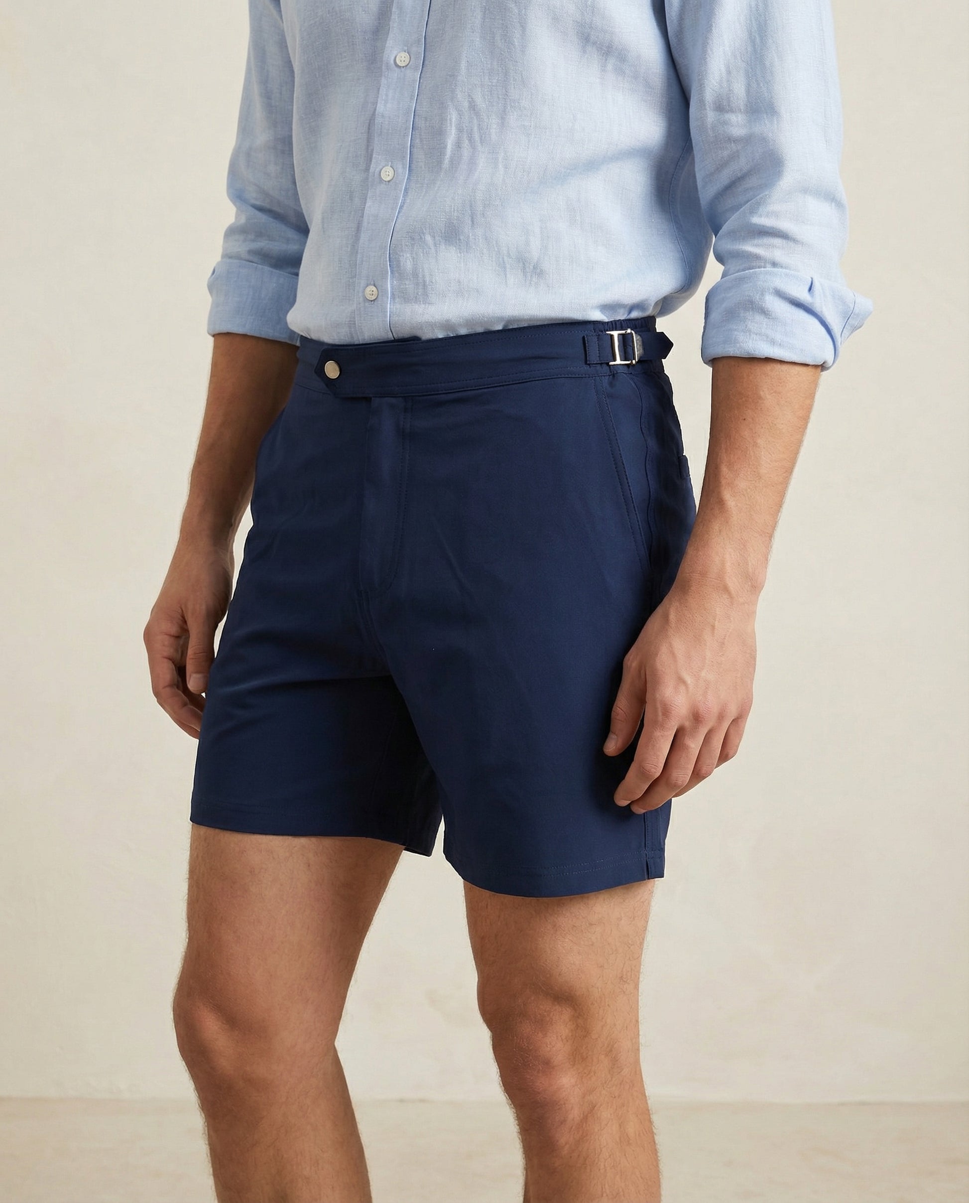 Close-up of Riviera navy swim shorts featuring structured waistband and metal side buckle.