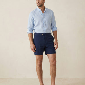 Apprivió Riviera navy swim shorts with side buckle waistband, styled with linen shirt for refined summer look.