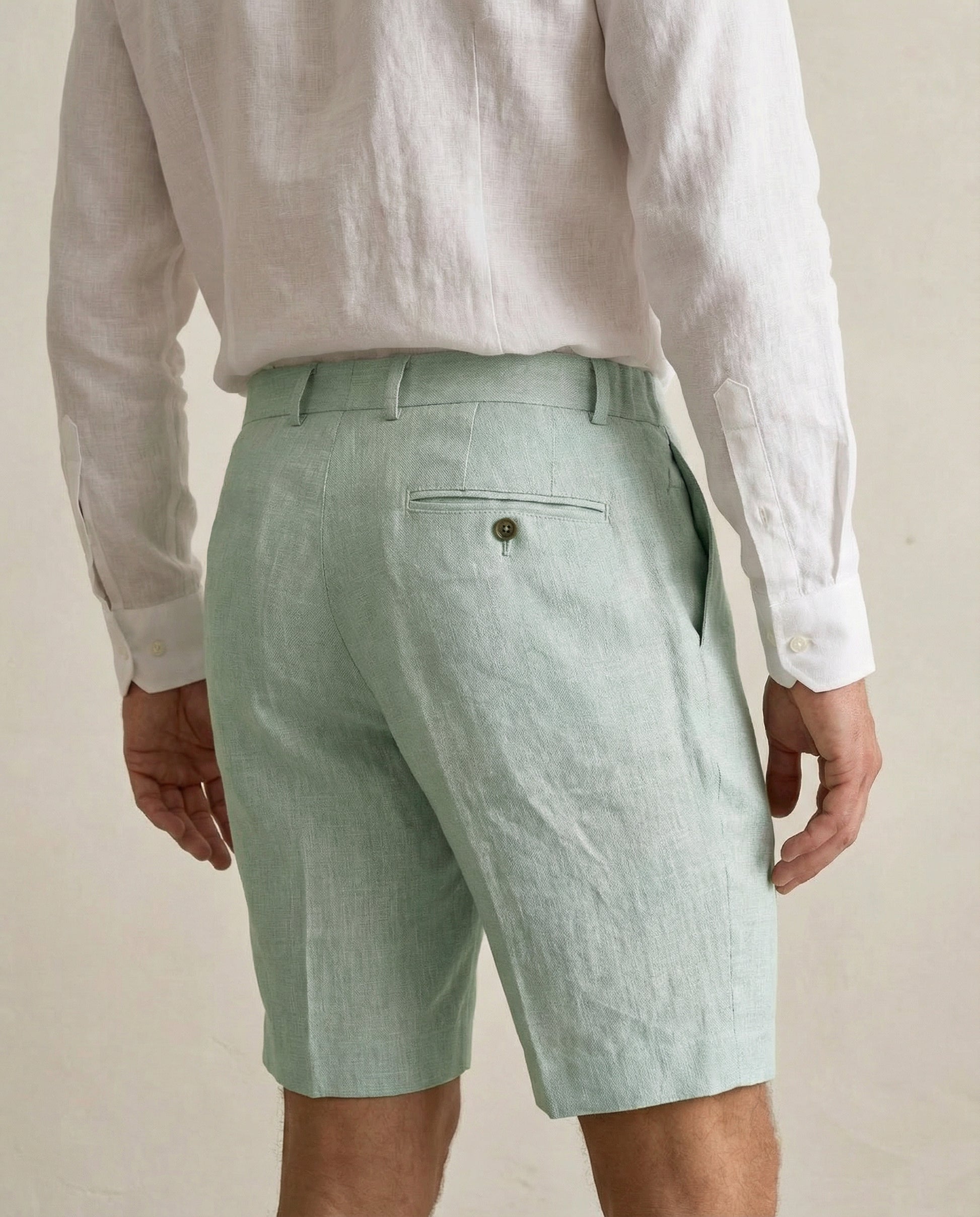 Back view of men’s sage green linen shorts with rear pocket