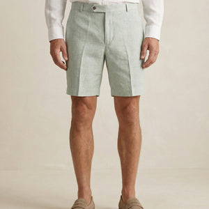 Detail of sage green linen shorts fabric and tailored waistband