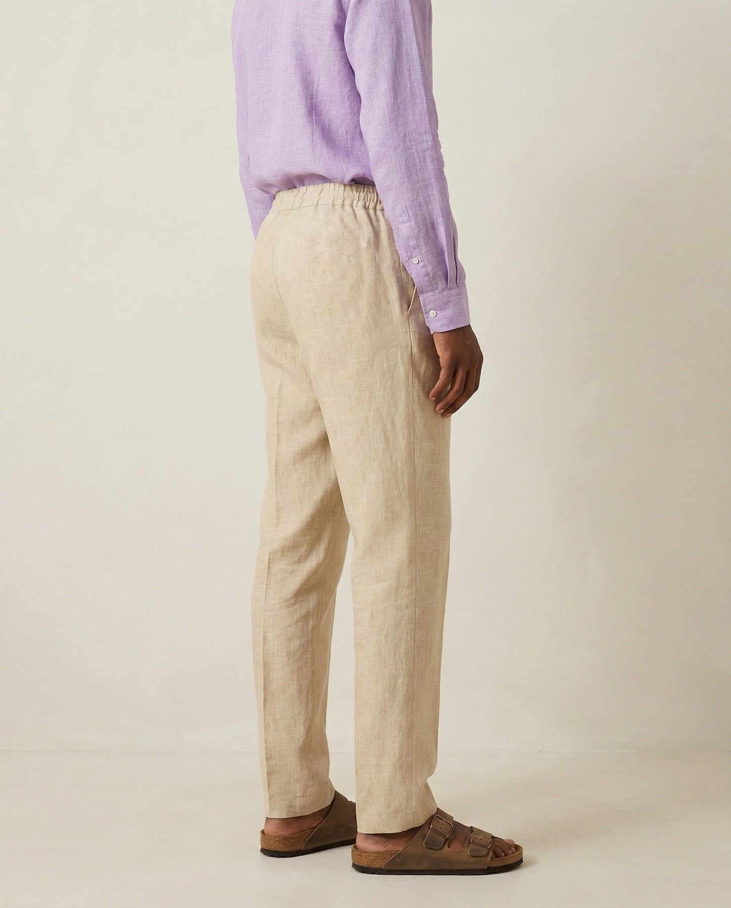 Back view of men’s beige linen trousers with elastic waistband