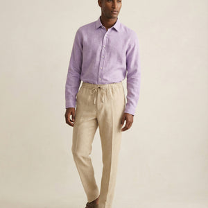 Men’s Senna beige linen trousers worn with lilac linen shirt, full outfit view